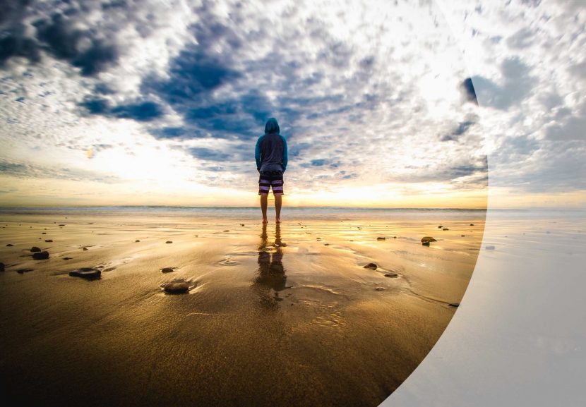 Mann von hinten, schaut aufs Meer, stimmungsvoller Wolkenhimmel